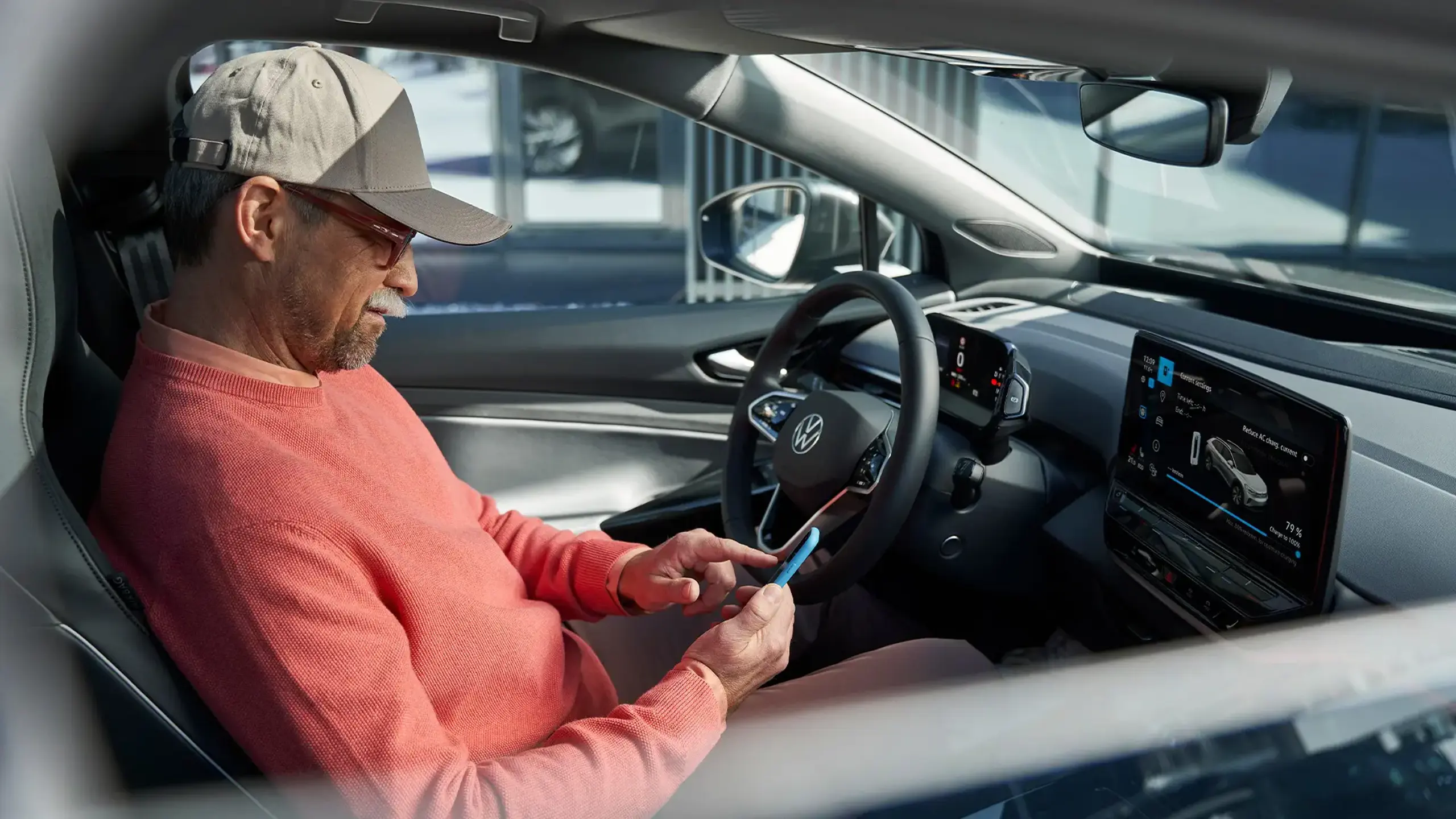 Man sidder på førersædet og kigger i sin telefon