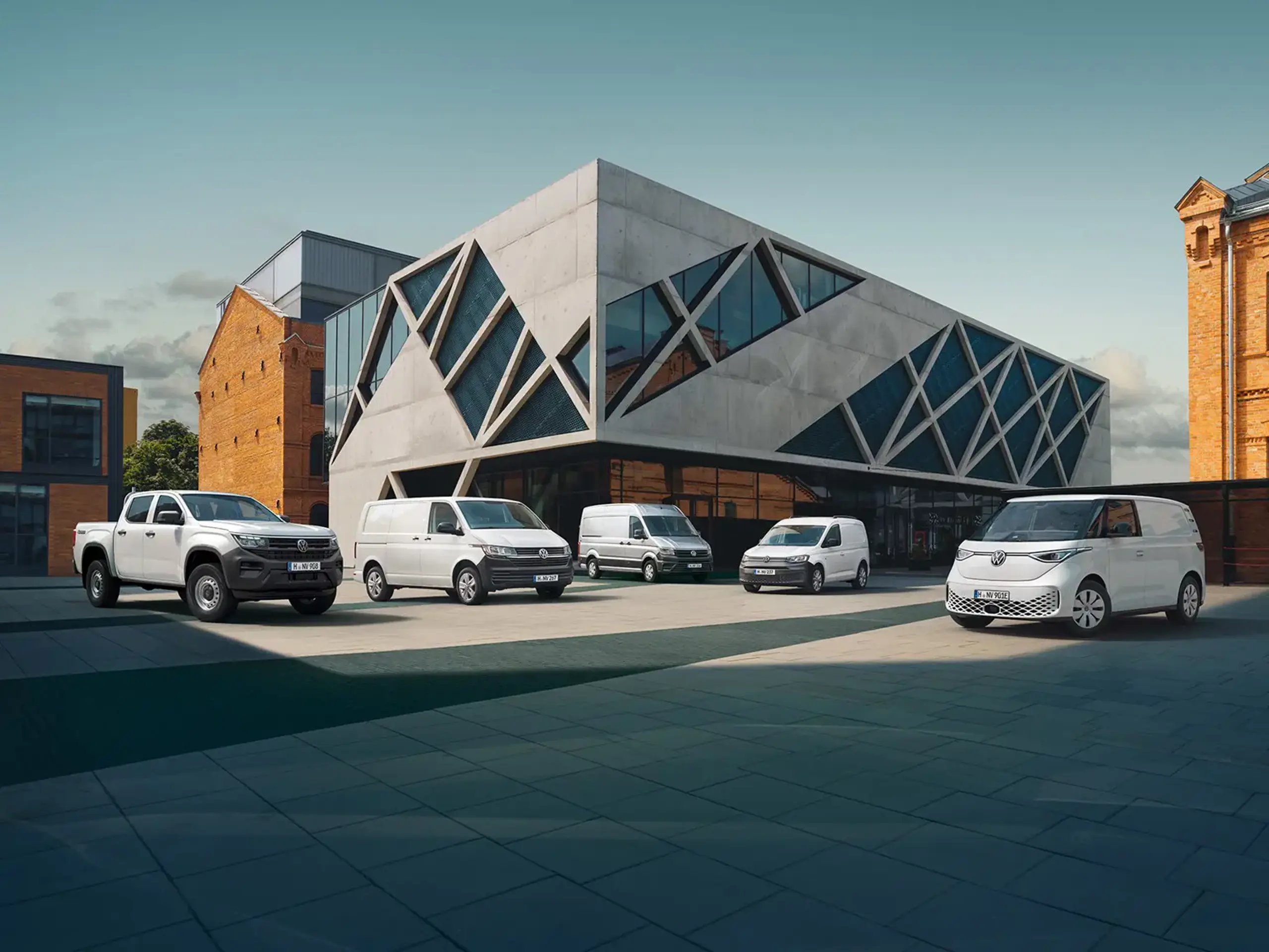 Fem forskellige erhvervsbiler parkeret foran forhandler